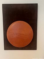 Front view of framed 3D leather moon art on velvet background