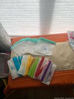 All 15 silicone storage bags laid out showing sizes and colored zippers