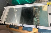 Horizontal white framed mirror with hooks visible