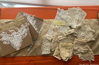 Entire lot with packaged appliqués and loose vintage lace on fabric backdrop