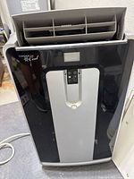 Front view of Commercial Cool portable air conditioner showing louvers and control panel