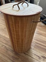 Full view of bamboo cylindrical hamper with lid in place