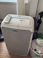 Front view of Danby portable AC showing remote on top, hose attached