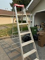 Full view of aluminum A-frame ladder standing outdoors