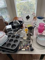 Overall view of lot on table showing muffin pan, storage containers, roasting pan, salad spinner, utensils