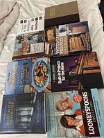 Array of eight hardcover books laid on bed