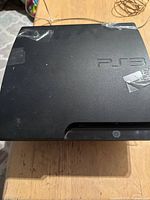 Top view of PS3 slim console showing logo and surface condition