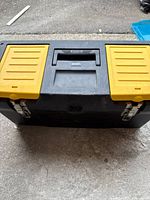 Closed toolbox front view showing yellow small-lid bins, handle and metal latches