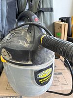 Stinger wet/dry vac close-up showing brand label, hose connection, dust on exterior