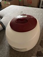 Top angled view showing burgundy lid and white body