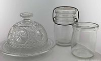 Group shot of pressed glass butter dish, bail-lid jar, and small jar