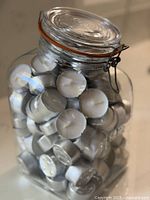 Closed glass canister packed with votive candles