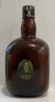 Front view of amber crackle glass Grand Old Parr bottle showing label and cap