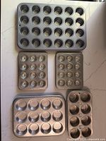 Group shot of five baking pans: 24-cup mini muffin, two fluted tart pans, 12-cup muffin, 8-cup muffin