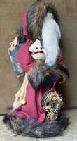 Front view of 19" Father Christmas figurine, showing burgundy robe, faux fur trim, white beard, teddy bear, toy sack and horn