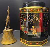 Tin and bell side by side showing relative sizes and design details