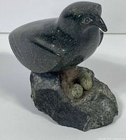 Front view of serpentine bird on rough base with eggs visible