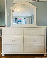 Front view of dresser with attached mirror showing overall design and six drawers