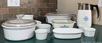 Full lot showing all CorningWare pieces, lids, ramekins and percolator