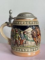 Front view showing alpine village scene and pewter lid