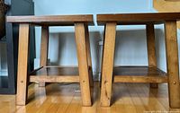 Side view of both wooden end tables showing legs and lower shelves