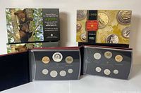 Open presentation cases showing encapsulated coins from 1999 and 2013 sets