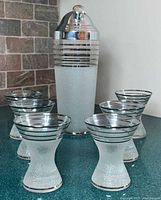 Shaker and six matching glasses grouped together