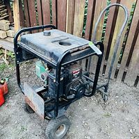 Full view of generator on wheels next to hand dolly
