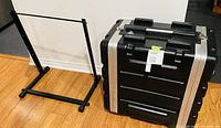 Flight case and studio rack frame side by side on floor