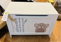 Full view of white toy chest front with painted birch trees and bear