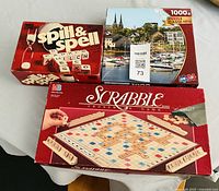 Overview of three boxed items: Scrabble game, Spill & Spell game, Sure-Lox puzzle
