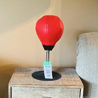 Front view of red tabletop punching bag on wood table