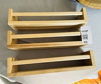 Three identical unfinished pine IKEA spice racks, front dowel bars visible