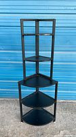 Full view of corner shelf showing metal frame and four shelves