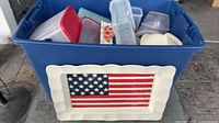 Blue tote filled with plastic containers; American flag platter leaning against front