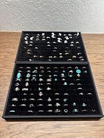 Two velvet ring display trays filled with assorted fashion rings