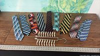 Full lot view with nine ties and tie caddy laid on table