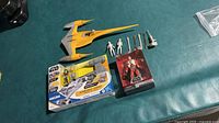 Group shot showing all items: loose yellow/grey starfighter, boxed N-1 Starfighter set, boxed Poe Dameron figure, loose micro figures and blasters