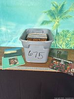 Overall lot view with grey tote full of LPs and three visible record covers on table