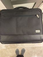 Front view showing APC logo, front zip pocket and overall material