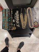 Overview of seven necklaces laid on black shelf