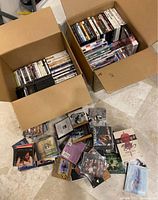Two open boxes and loose pile showing large quantity of DVD cases