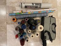 Group shot of all thread cones, rolls, messenger bag