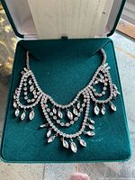 Necklace displayed in green velvet case showing full draped design and crystal arrangement