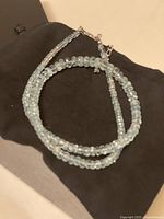 Necklace coiled on black box showing beads and clasp