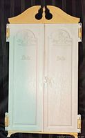 Front view of closed cream/yellow plastic wardrobe showing crest and embossed logos