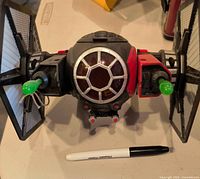 Front view of Hasbro 2015 First Order TIE Fighter toy with projectiles and wings attached; pen for scale not included