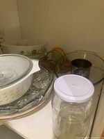 Interior of cupboard showing Pyrex bowls, clear bakeware, glass jar