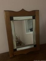 Front view showing wood frame, decorative glass side panels, mirror surface