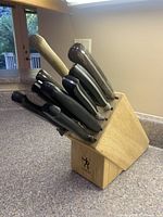 Wooden Henckels knife block with eight assorted knives inserted